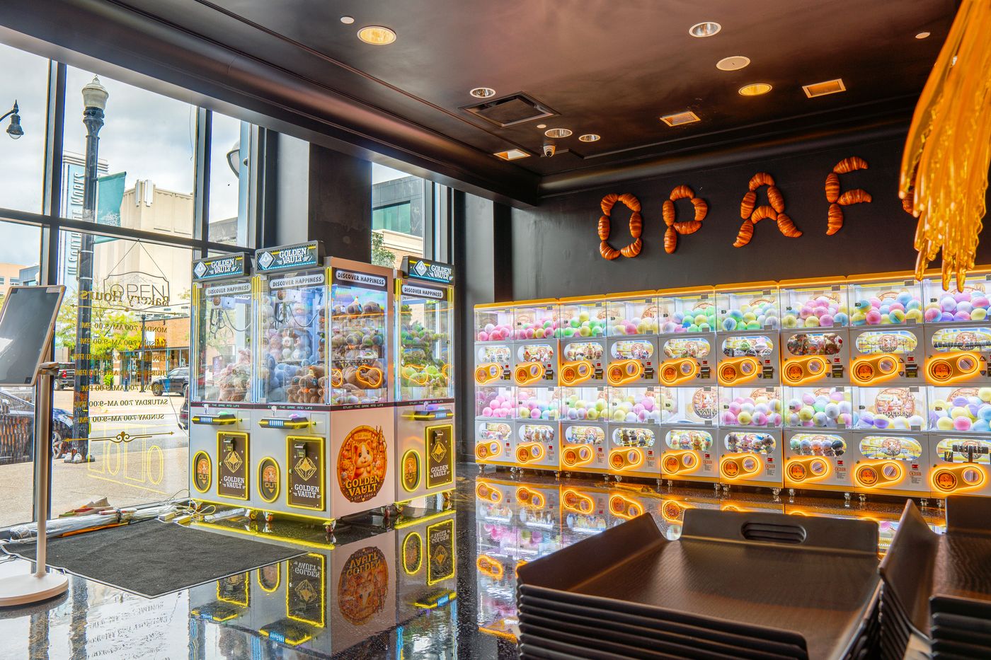 Capsule toy wall and claw machines beneath the croissant OPAFE sign